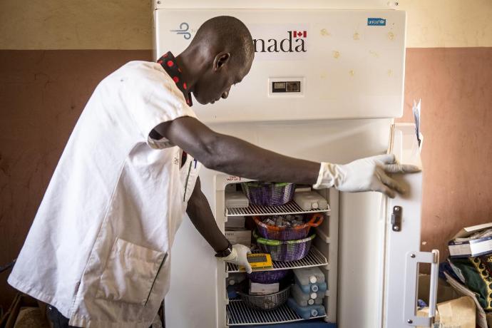 Agent de santé utilisant un réfrigérateur à vaccins sur le terrain